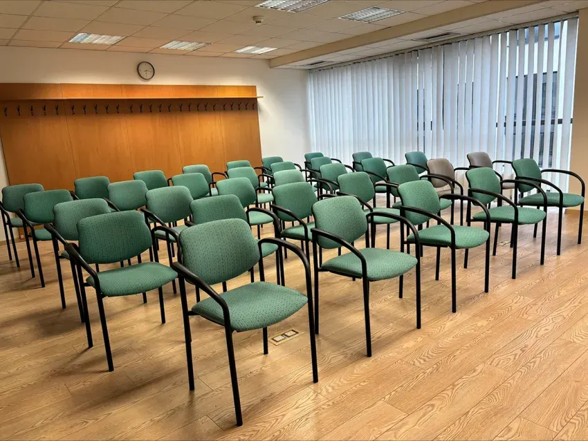 Kino-Anordnung im Schulungsraum des Hotel TeleDom Košice — Reihen grüner Stühle ohne Tische für Vorträge und Kurse